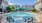 a swimming pool with chairs and umbrella