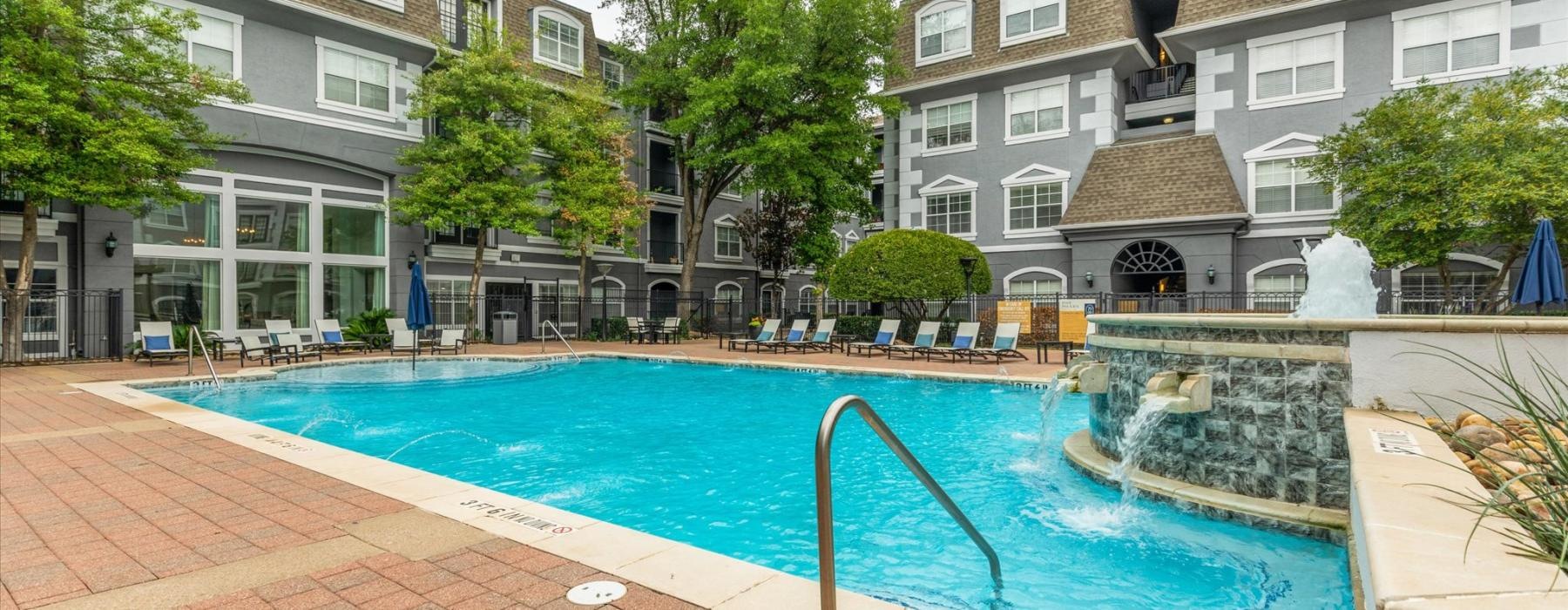 a pool in a courtyard with buildings in the background